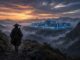 A samurai in a straw hat walks a mountain path toward an illuminated data center at sunset